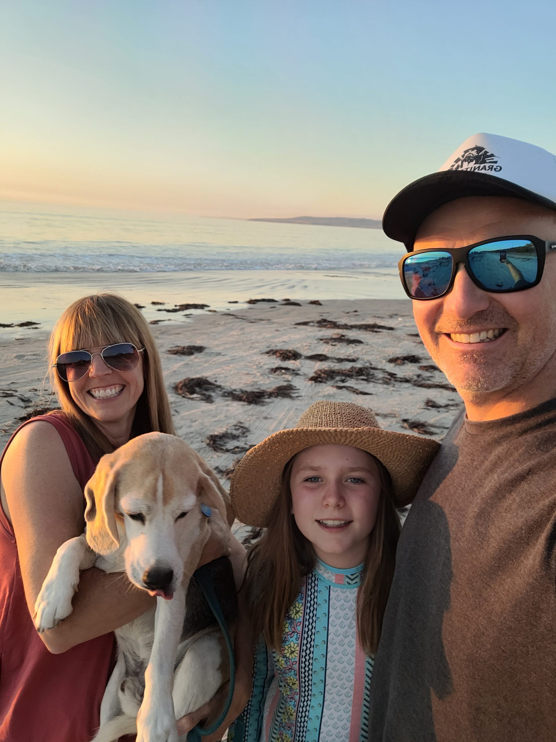 Social Ladder director Steve Davenport and his family and dog on an beach during sunset.